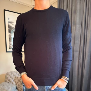 Svart långärmad tröja - Stilren mörkblå tröja i merinoull från uniqlo. Perfekt till vardags eller att ha över en skjorta. Storlek S men sitter som M.