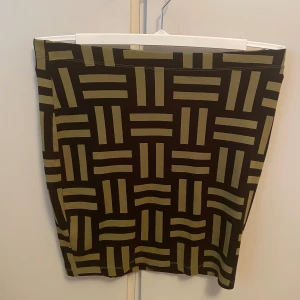 *NY*Svart/Grön kjol, stl M, Fr Me&I - Snygg kortare kjol med ett mönster av svarta och gröna ränder. Kjolen är tight och har en enkel design, mjuk o skön. Endast provad, i nyskick, inget att anmärka på, 88% viskos, 11% polyester, 2% elastan. Passar ev även mindre L då midjan är stretchig