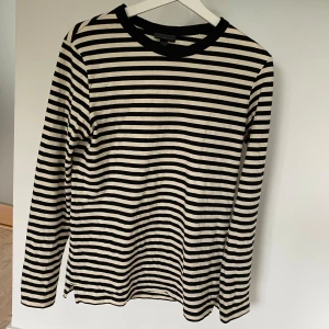 Randig långärmad tröja från H&M - Säljer en stilren och klassisk randig tröja från H&M i storlek XS. Den är svart och vit med långa ärmar och en bekväm passform. Perfekt för både vardag och lite mer avslappnade tillfällen. Tröjan är i bra skick och redo för en ny ägare!