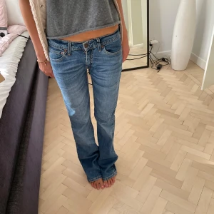 Blå jeans med bootcut - Säljer ett par snygga blå jeans med bootcut. De är lågmidjade och har en klassisk femficksdesign. Perfekta för en avslappnad stil! Levis . midjemått ungefär 74, och innerbens längd ca 85