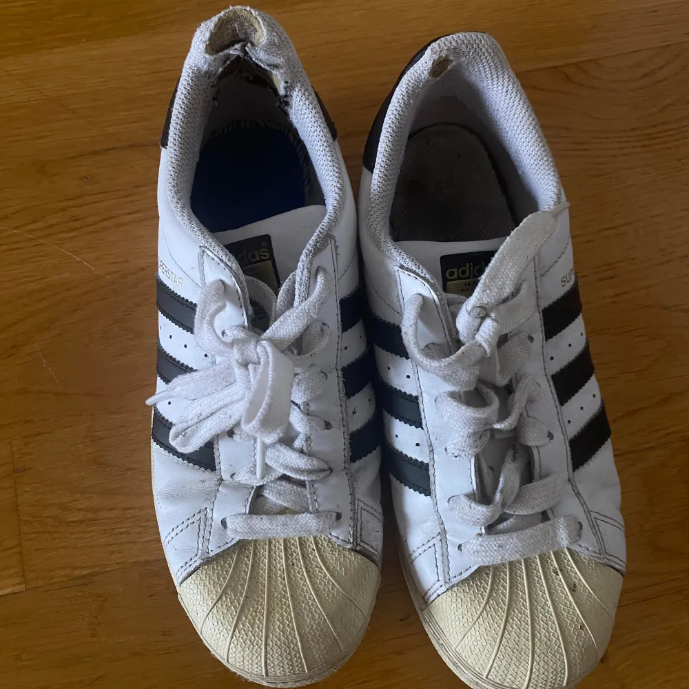 Ett par adidas superstar skor som köptes för år sedan och är lite slitna som ni kan se på bilden. Skor.