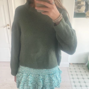 Grön stickad tröja från Pull&Bear - Säljer en supermysig grön stickad tröja från Pull&Bear. Den är perfekt för höst och vinter med sin varma och sköna känsla. Tröjan har långa ärmar och en normal passform som gör den lätt att matcha med olika outfits. Perfekt för en avslappnad stil!