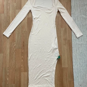 Beige långklänning från SHEIN - Säljer en superfin beige långklänning från SHEIN. Den är ribbad och har en tight passform som verkligen framhäver figuren🤗Aldrig använd med prislapp🥰