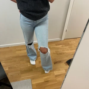 Jeans med hål - Högmidjade. Hål över knäna. I toppenskick.