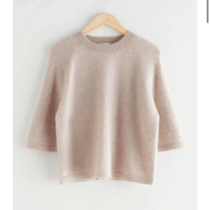 Beige stickad tröja - Mysig beige stickad tröja med trekvartsärm och rund hals. Perfekt för kyligare dagar och enkel att matcha med olika outfits.