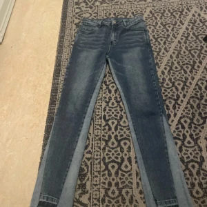 Blå jeans från NVLTY - Snygga blå jeans från NVLTY med en klassisk femficksdesign. De har en slim passform och är tillverkade i en bomullsblandning med lite stretch för extra komfort. Perfekta för en stilren look.