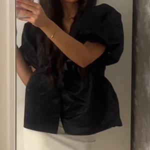 Svart blus med puffärmar - Elegant svart blus med stora puffärmar från Nelly.💓💓 Perfekt för en stilren look. Använd endast vid ett tillfälle 💓💓