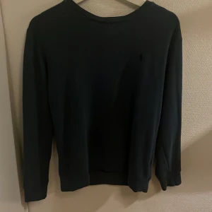 Mörkblå tröja från Polo Ralph Lauren - Säljer en stilren mörkblå tröja från Polo Ralph Lauren. Tröjan har en klassisk design med rund hals och långa ärmar. Perfekt för en avslappnad och elegant look. Storlek: 14-16 år. Skriv om ni har frågor!