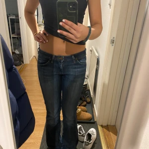 Blå bootcut jeans från Wrangler - Snygga bootcut jeans från Wrangler med klassisk femficksdesign och kontrastsömmar. De har en låg midja och bootcut-stil som ger en avslappnad look. Perfekta för en casual outfit. Pris kan diskuteras 💕