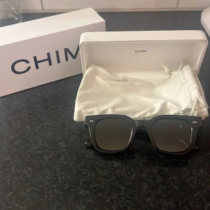 Svarta solglasögon från Chimi  - Snygga svarta solglasögon från Chimi med en stilren design, CHIMI 04. De har en fyrkantig form och mörka linser som ger ett coolt och modernt intryck. Perfekta för att skydda ögonen med stil. Levereras med ett elegant fodral. Oanvända, nypris 1350kr. Pris går att diskuteras. 