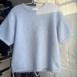 Ljusblå stickad tröja - Mysig ljusblå stickad tröja med korta ärmar från Gina tricot. Perfekt för en avslappnad stil och kan enkelt matchas med olika outfits. Sista bilden är en bild från gina på samma modell, men annan färg. (Hittade inga bra bilder på den blåa) Köptes för 299, mitt pris ligger på 99 (pris kan diskuteras)💕🫶🏼