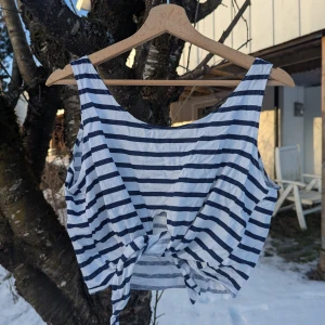Women blue and white striped crop top - Selling a striped crop top in blue and white. The top has a tie at the front and is sleeveless, perfect for warm days. It has a relaxed and summery style. No labels, size is approx S-M.