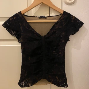 Svart spets topp  - Fin svart lite glittrig spets topp från Sandro! Själv aldrig använd utan köpt på vinted med säljer vidare då det inte passar mig. Fint skick men några lösa trådar men som inte märks av.💞