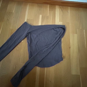 Grå offshoulder topp - Snygg grå offshoulder topp med långa ärmar. Perfekt för en stilren look. Passar bra till både jeans och kjol och fest 