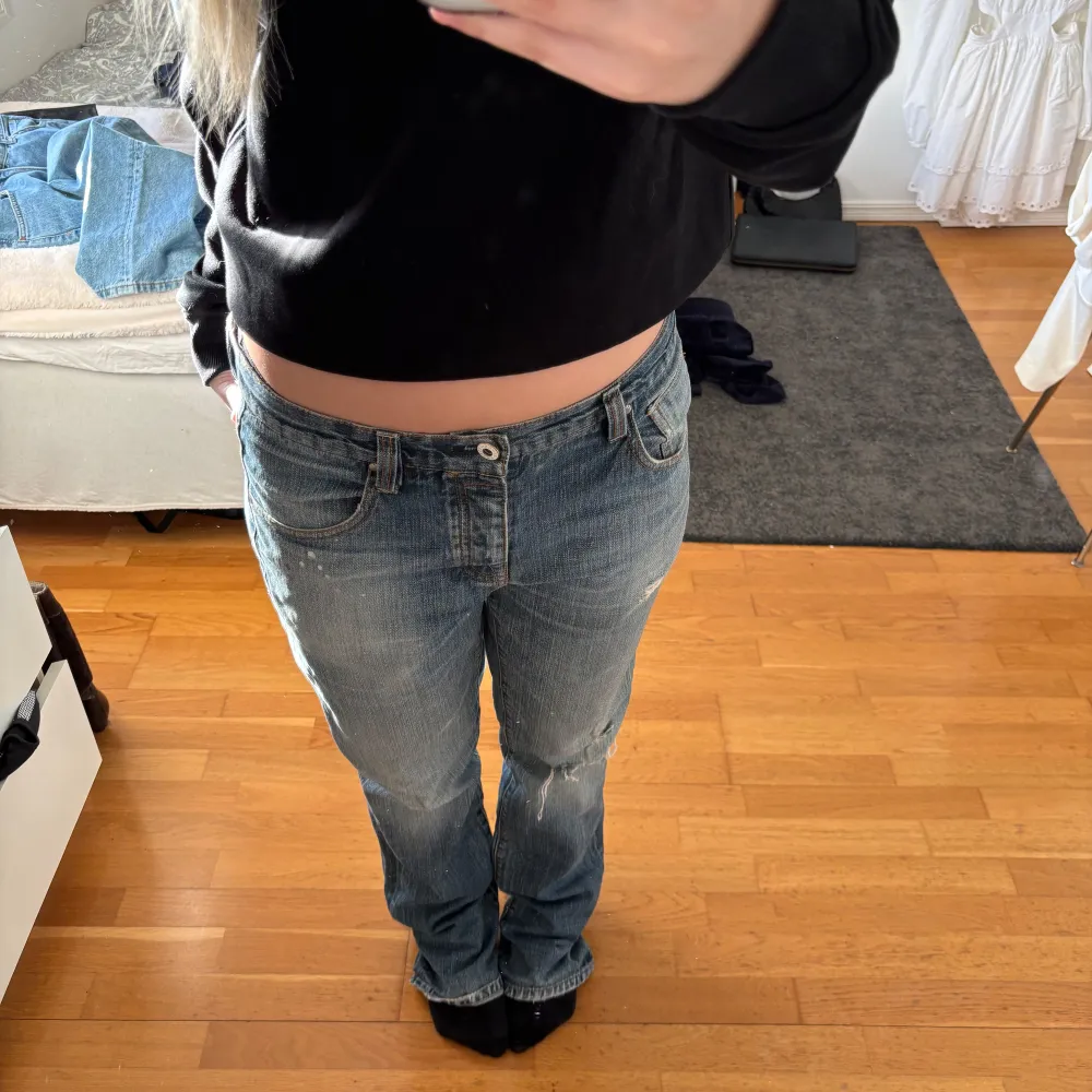 Säljer ett par blå jeans med slitningar och en klassisk femficksdesign. De har en låg midja och en straight passform, vilket ger en avslappnad look. Perfekta för en casual stil. Storleken är 32/34 (jeans) och passar mig som är en S utan att behöva ha bälte! . Farkut & Housut.