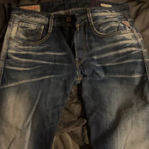 Blå jeans från Replay Anbass - Snygga blå jeans från Replay Anbass med en cool tvättad look. De har klassiska fem fickor och en knappgylf. Perfekta för en avslappnad stil.