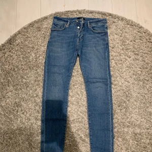 Blå slim jeans från NEUW - Snygga blå skinny jeans från NEUW i storlek 32. De har en klassisk femficksdesign och stängs med dragkedja och knapp. Perfekta för en stilren look. Nypris ligger på cirka 190$     