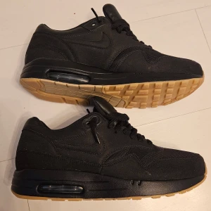 Svarta Nike Air Max x A.P.C stl 41 - Snygga svarta Nike Air Max sneakers med klassisk design och bekväm passform. Skorna har en svart ovandel med snörning och en ljusbrun sula. Oanvända.