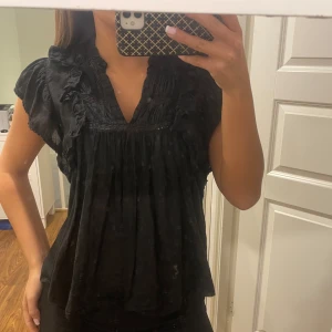 Svart blus från Zadig & Voltaire - Snygg svart blus från Zadig & Voltaire med volangdetaljer och v-ringning. 