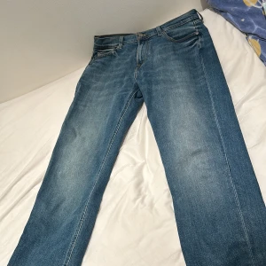 Blå jeans från Lee - Säljer ett par klassiska blå jeans från Lee i modellen Austin. De har en normal passform och är tillverkade i slitstarkt denim. Perfekta för en avslappnad stil. Storleken är W30 L34. Vid snabb affär kan priset sänkas 