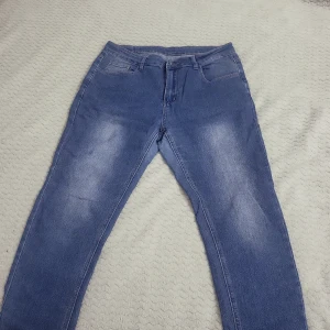 Blå jeansbyxor - Snygga blå jeansbyxor med en klassisk femficksdesign. De har en lätt tvättad look och är perfekta för en avslappnad stil. Passar bra till både t-shirt och skjorta.