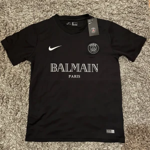 PSG x Balmain Fotbollströja - Säljer denna feta PSG x Balmain tröja som är perfekt inför vår och sommar. Aldrig använd, utan endast testad. Den är storlek S men sitter mer som M. Tveka inte att skriva vid frågor!