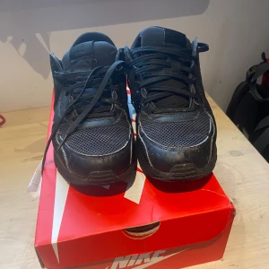 Svarta Nike air Max excee  - Säljer ett par svarta Nike sneakers med snörning. Skorna har en sportig design med en robust sula och är tillverkade i syntetmaterial. Perfekta för en casual look. Ny pris 1400kr.