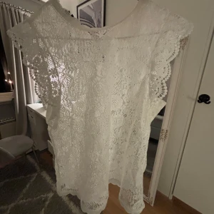 Vit spetblus från Pieces - Säljer en superfin vit spetblus från Pieces i storlek S. Den är perfekt för sommarens alla fester med sin romantiska spets och lösa passform. Blusen är ärmlös och har en vacker, detaljerad spetsdesign som ger en elegant touch. Perfekt för både vardag och fest! 🌸