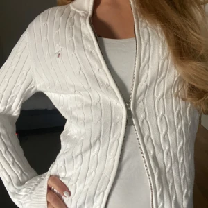 Vit kabelstickad kofta från Gant - Säljer en superfin vit kabelstickad kofta från Gant. Den har en dragkedja framtill och är i mycket bra skick. Perfekt för både vår och höst, och funkar lika bra till vardags som till lite finare tillfällen. Storleken är dam S Passa på att fynda denna klassiker! 🤍