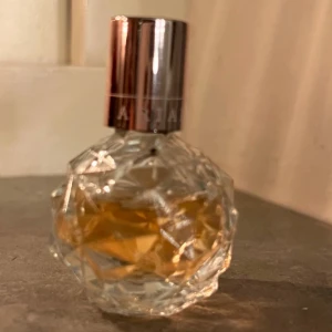 Ariana Grande parfym (Ari)🩷 - Ariana Grande parfym. Doften heter ARI. Elegant parfym i en kristallformad flaska med en ljusrosa vätska. Flaskan har en roséguldfärgad kork som ger en lyxig känsla. Perfekt för den som vill ha en stilren och sofistikerad doftupplevelse. 7,5 ml