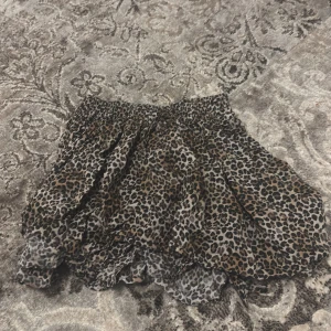 Leopardmönstrad kortkjol - Snygg leopardmönstrad kortkjol med elastisk midja. Perfekt för att ge en vild touch till din outfit. 🐆