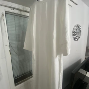Vit långklänning - Elegant vit långklänning med långärmad design. Perfekt för en stilren och klassisk look. Klänningen har en enkel och tidlös stil som passar många tillfällen. Den är lite genomskinlig men det går att fixa. Passar längderna 150-163cm och är storlek S