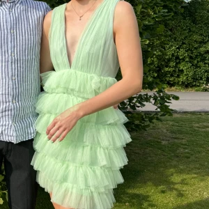 Ljusgrön klänning från Bubbleroom - Säljer en ljusgrön klänning från Bubbleroom med volanger och djup v-ringning. Klänningen är ärmlös och har en kort längd, perfekt för sommarens festligheter. Klänningen är från Andrea Norrman x bubbleroom kollektionen, klänningen är använd endast en gång💚