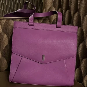 Lila skinnväska  - Snygg lila handväska i skinn 💕 Använd enstaka gånger och är lite nött på ena hörnet. Axelrem saknas! 