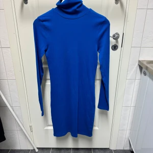 Blå långärmad klänning med polokrage - Snygg blå klänning från BikBok med lång ärm och polokrage. 