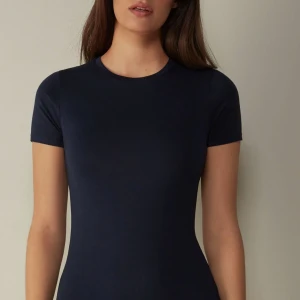 Intimissimi Kortärmad topp - T-shirt från intimissimi i marinblåa. Den har en tajt passform och lite. Längre i modellen så passar bra med lågmidjade byxor🌼