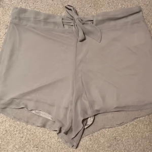 Grå shorts från Bik Bok - Säljer ett par grå shorts från Bik Bok i storlek S. De är supermjuka och bekväma med en söt knytning framtill. 
