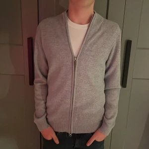 Grå kofta med dragkedja - Hej! Jag säljer den hära stenströms helzippen. Den har extremt bra skick, inge defekter. Nypris är från 1500-2000kr