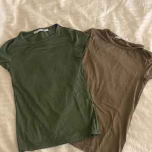 Två t-shirts i grönt och brunt - Säljer båda mina ”fit me” t-shirts från lager då de inte kommer till användning. Säljer 1 för 50kr och båda för 90kr 
