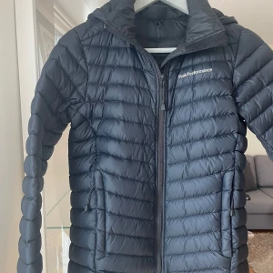 Svart dunjacka från Peak Performance - Säljer en svart dunjacka från Peak Performance i mycket bra skick. Jackan är quiltad och har en dragkedja framtill. 