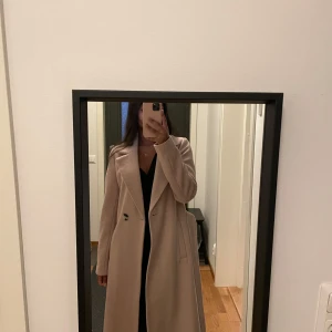 Lång kappa - Säljer den här jättefina kappan från Only som tyvärr inte kommer till användning. Kappan är i fint skick💓 Den är i beige/rosa färg