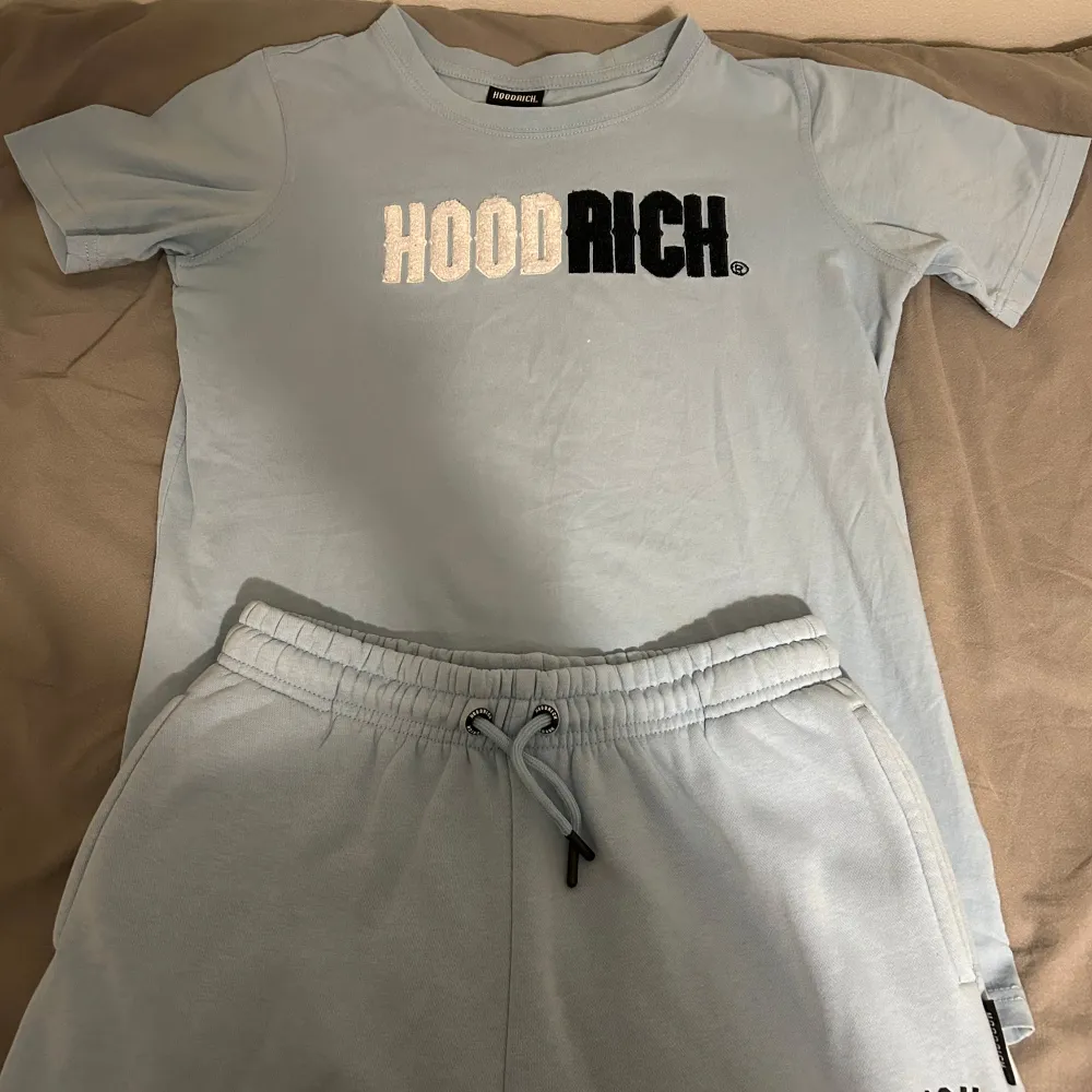 Säljer ljusblå t-shirt och byxor från Hoodrich i storlek XL för åldrar 13-15 år.. T-shirts.