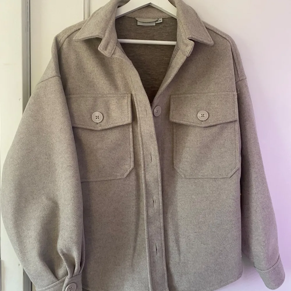 Säljer en snygg beige overshirt i mycket bra skick. Den har en normal passform och är långärmad med stora knappar framtill. Perfekt för höst och vår, och funkar både till vardags och lite finare tillfällen. Två stora fickor på bröstet ger en cool look. 🧥✨OBS frakt tillkommer vid paket som måste skickas.. Jackor.