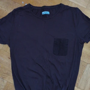 Brun t-shirt med ficka från Elvine - Snygg brun t-shirt från Elvine med en praktisk bröstficka. Perfekt för en avslappnad stil. Tillverkad i mjukt material för extra komfort.