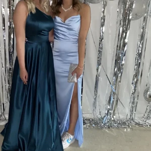 Ljusblå långklänning med öppen rygg - Säljer en ljusblå balklänning med öppen rygg och slits. Klänningen har en tight passform och är axelbandslös. Köpt på här på plick för 700kr. Banden är avkortade en bit då de va väldigt långa❤️pris går att diskutera