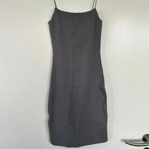 Grå klänning från Zara - Snygg grå klänning från Zara med smala axelband. Perfekt för en stilren look. Klänningen har en enkel och elegant design som passar till många tillfällen. Aldrig använd!