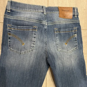Blå dondup jeans - Säljer ett par snygga blå jeans från Dondup i modellen george i bra skick. De är i storlek L men har krympt en del. Perfekta för både vardag och fest! Skriv om ni är intresserade!