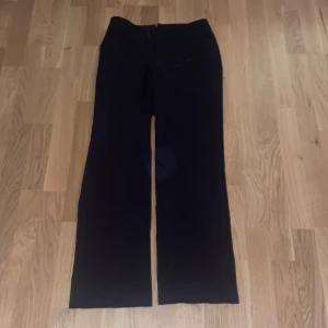 Kostymbyxor - Säljer ett par svarta kostymbyxor i mycket bra skick. De har en dragkedja framtill och en klassisk  rak passform. Perfekta för både vardag och festliga tillfällen. Passar bra till höst- och vintergarderoben. Strl 38 regular 