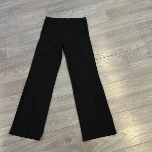 Svarta kostymbyxor - Snygga svarta kostymbyxor med hög midja och rak passform. Perfekta för en stilren look.