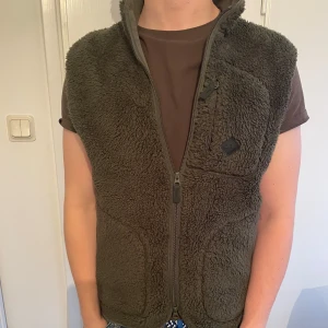 J Lindeberg fleece väst - Helt ny fleeceväst från J lindeberg. Aldrig använd, med prislappen kvar. Mörkgrön färg i storlek S som är perfekt för kalla vintern eller under våren!